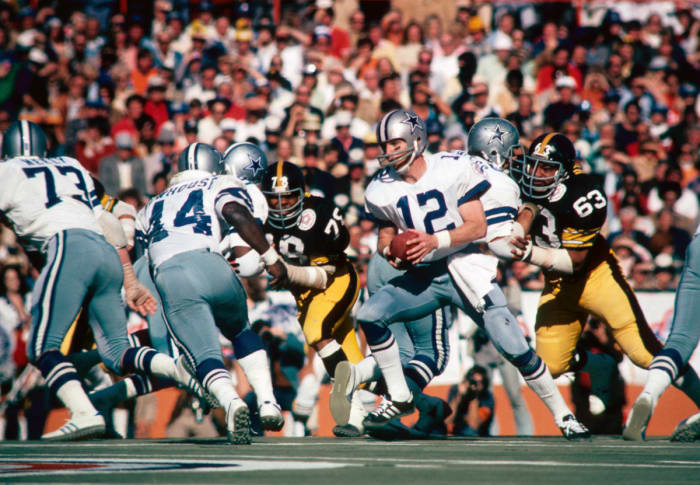Former Dallas Cowboys quarterback Roger Staubach holds the ball